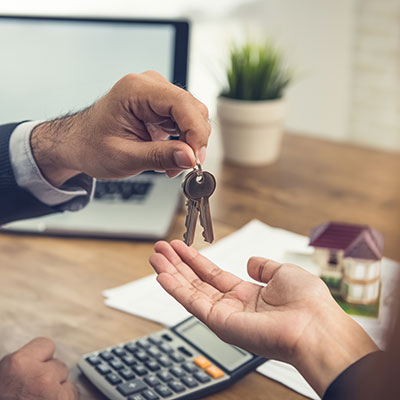 Real estate broker agent giving house keys to client