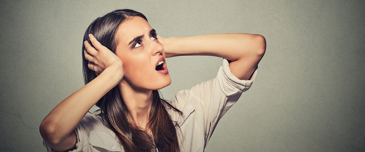 annoyed stressed woman covering her ears, looking up loud noise upstairs 