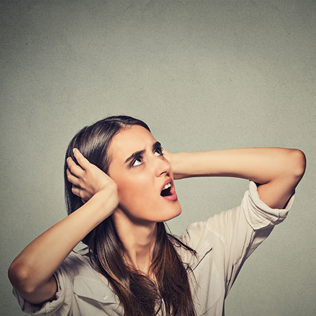 annoyed stressed woman covering her ears, looking up loud noise upstairs 